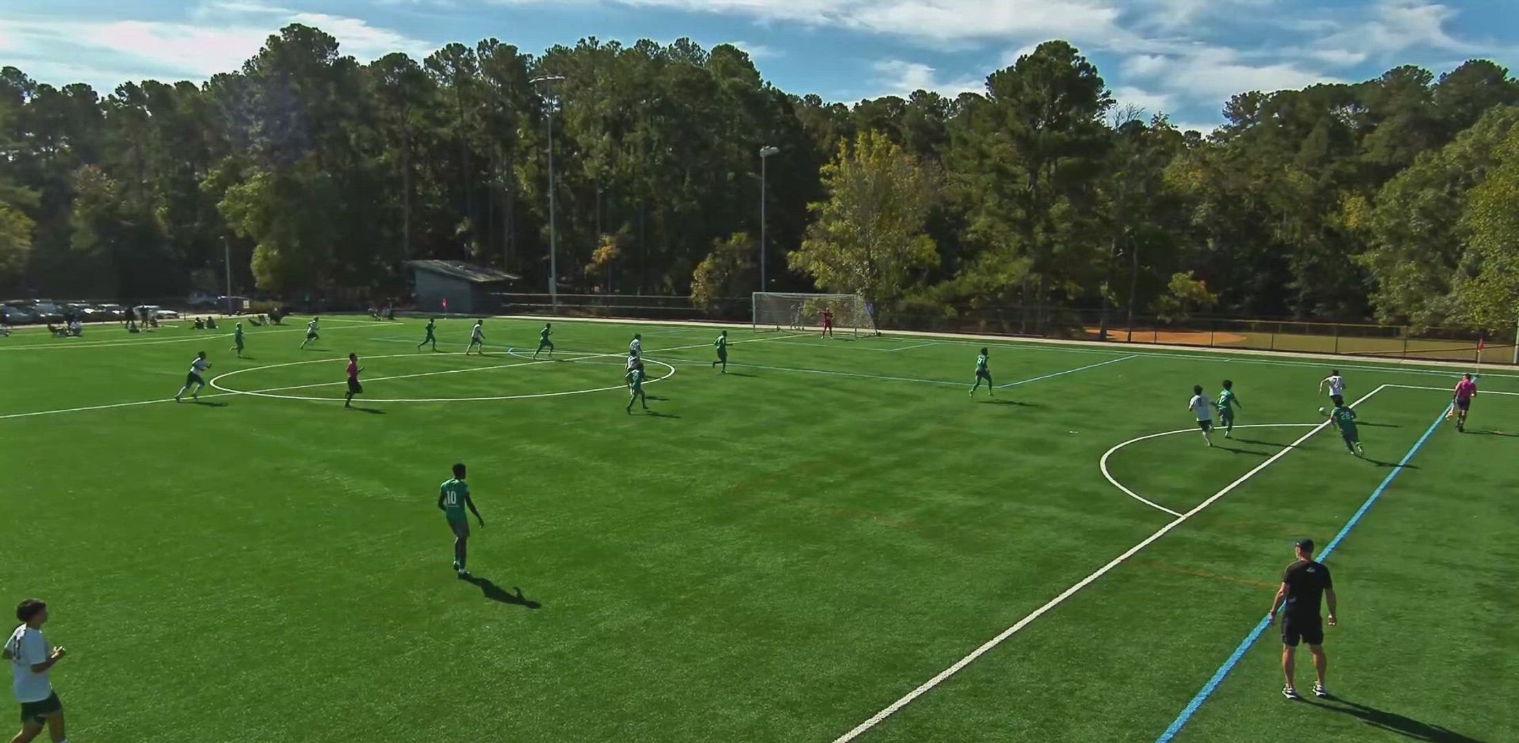 Triangle United players in green and white competing during a match on a Chapel Hill field