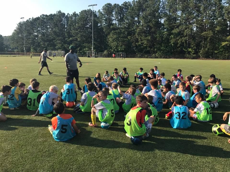 A coach instructing a group of players during a training session